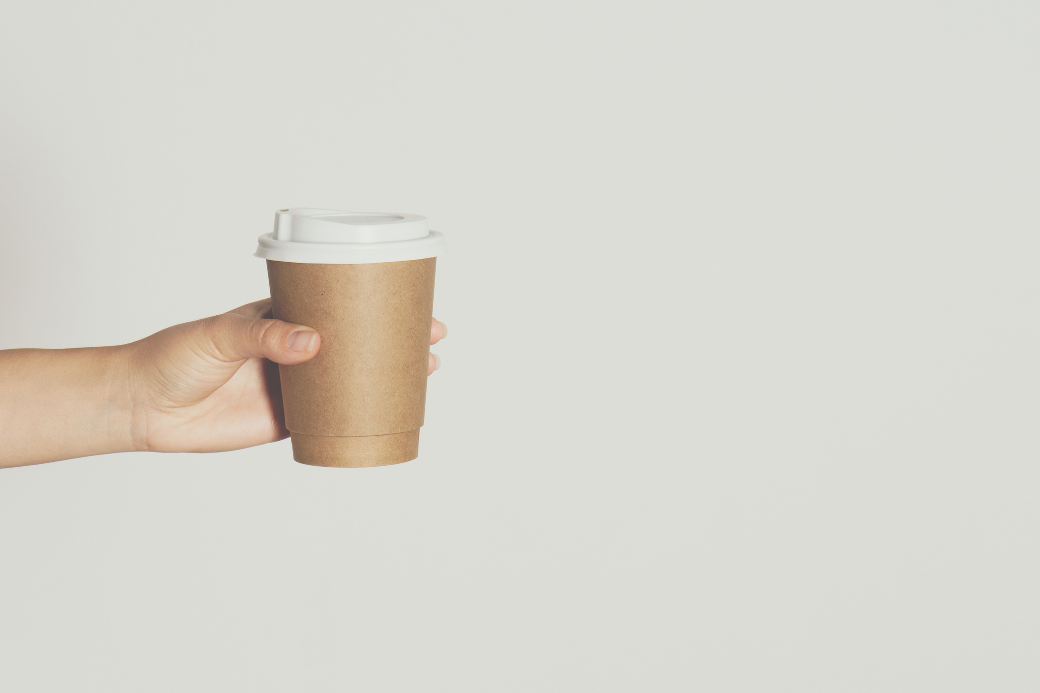 Woman's Hand Holding Brown Paper Takeaway Cup